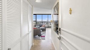 Eine moderne Wohnung mit Balkon, weißen Wänden und Blick auf die Stadt.