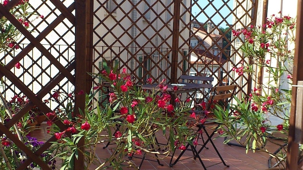 A courtyard with a wooden lattice fence, potted plants, and a tiled floor. - B&B Il Mulino (Guardiagrele)