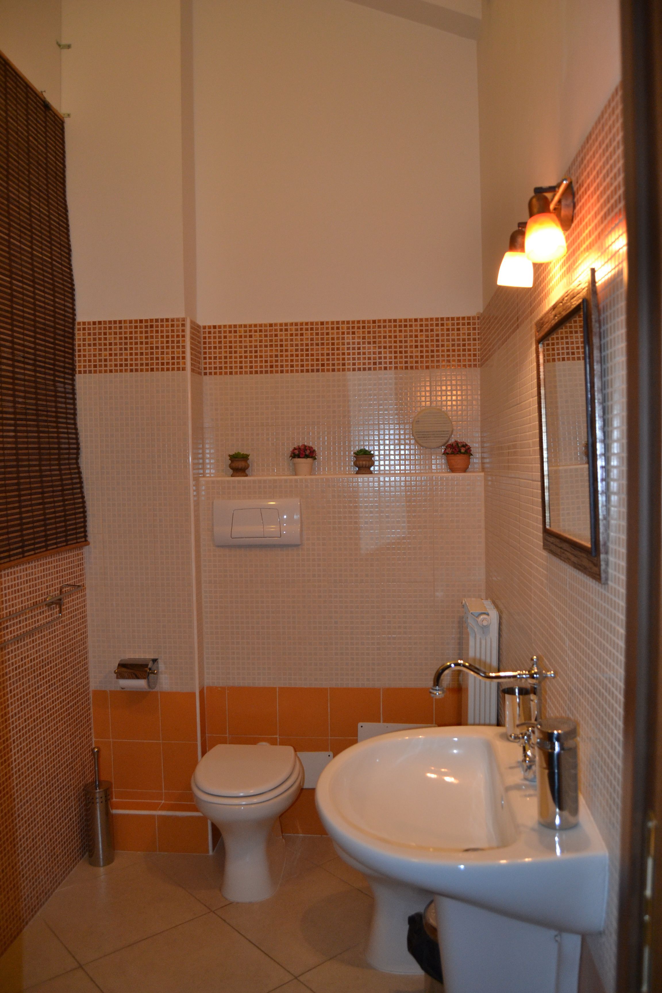 Une salle de bain avec des toilettes, un lavabo et des murs carrelés.