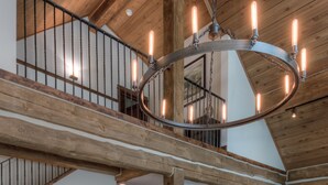 A spacious dining area with a wooden table and chairs, a herringbone-patterned cabinet, and a large chandelier. -   Luxury Home, Ideal Winter Ski-in/Ski-out or Summer Basecamp (Big Sky)