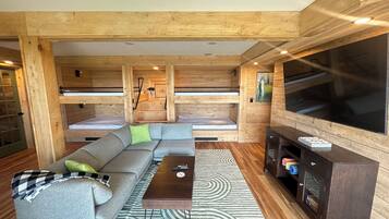 A wooden interior with a sofa, TV, and a patterned rug.