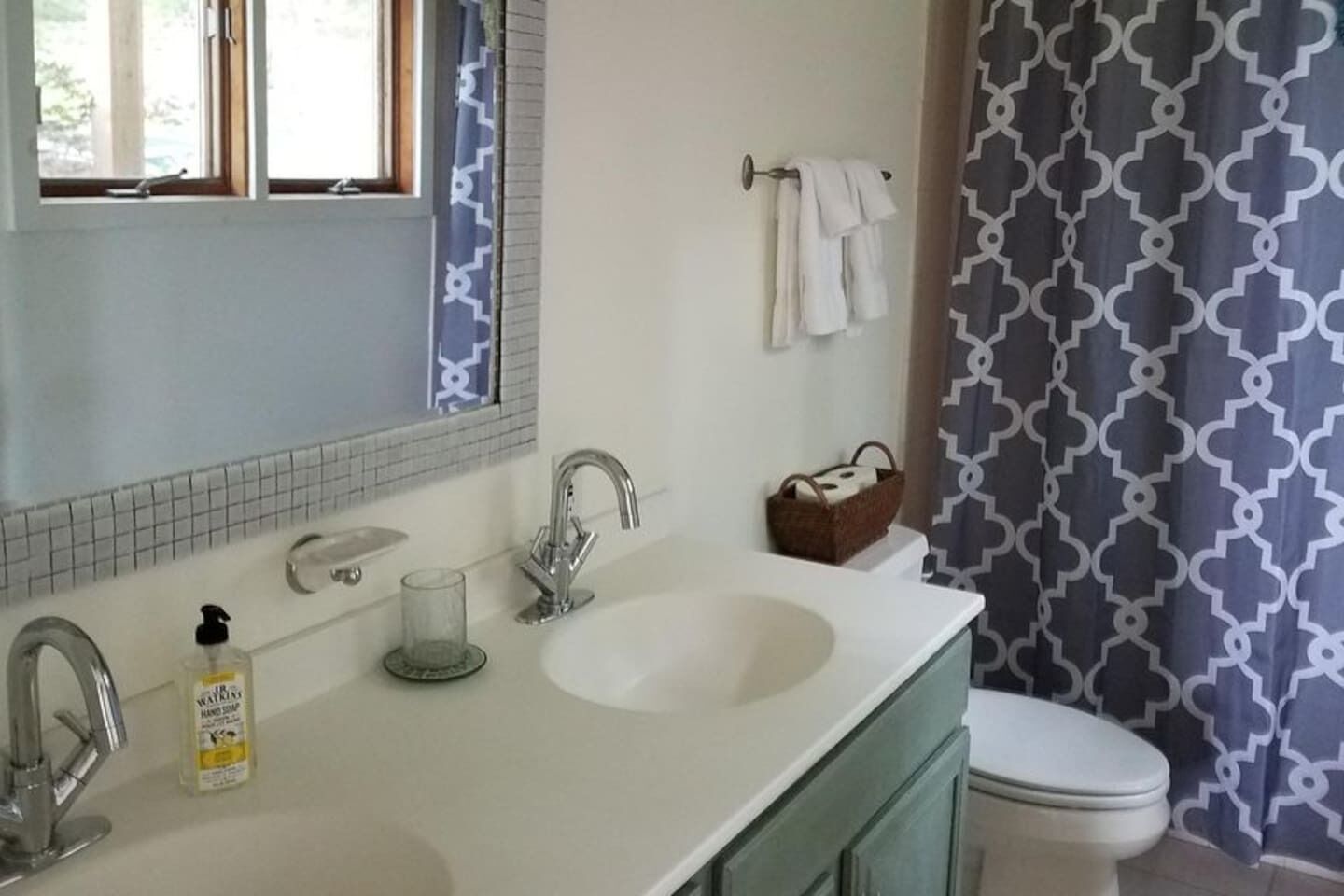 A bathroom with a white sink, a mirror, a towel rack, and a toilet.