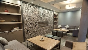A modern living room with a stone wall, grey sofas, a wooden coffee table, and a fireplace. - Amazing Penthouse-Private Hot Tub #2 of 5 - 410 (Canmore)