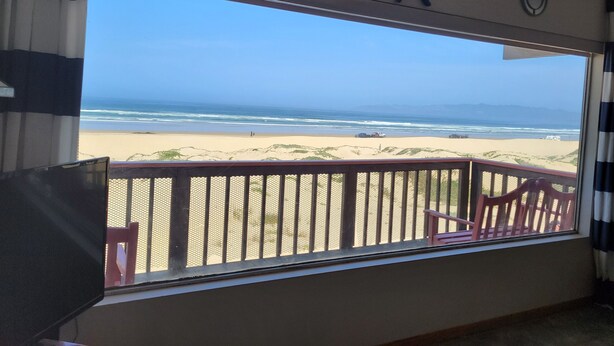 Una habitación con un amplio ventanal con vista a la playa.