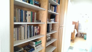 Una estantería llena de libros y un diccionario de crucigramas.