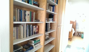 Una estantería llena de libros y un diccionario de crucigramas.