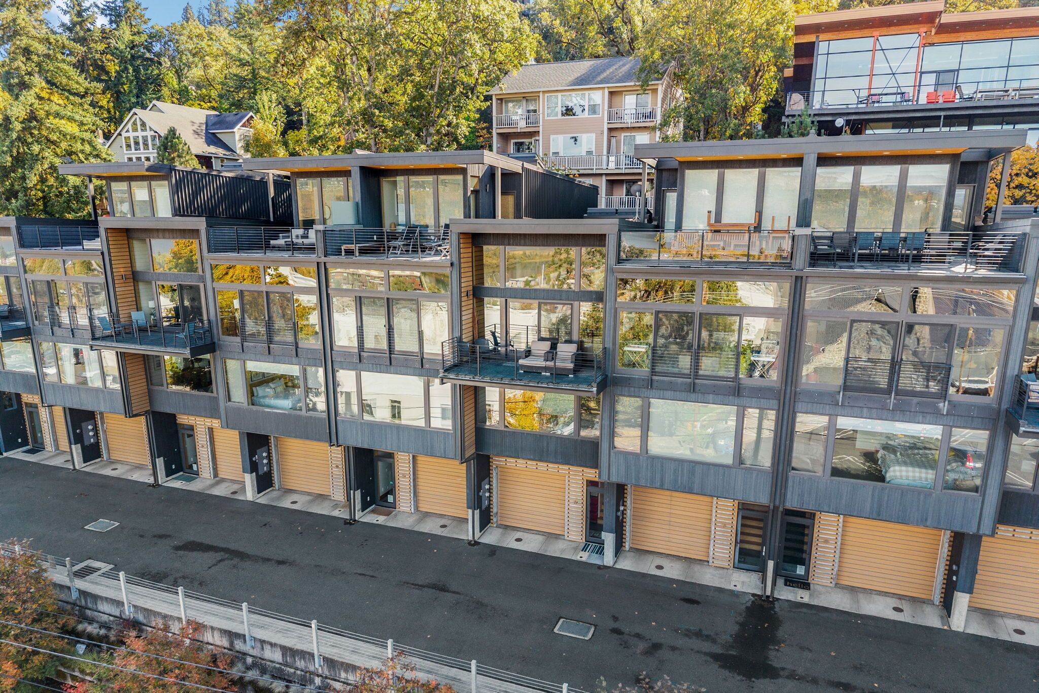 Un immeuble résidentiel moderne à plusieurs étages, doté de grandes fenêtres, de balcons et d’un toit plat.