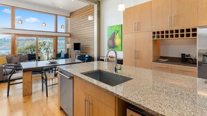 A modern kitchen with a granite countertop, stainless steel appliances, and wooden cabinets. - Best spot in town! Modern townhome, downtown Hood River, big views! (Hood River)