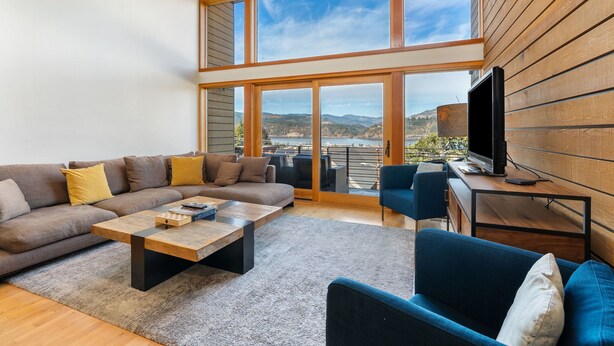 A modern living room with a large sofa, a coffee table, and a TV on a wooden desk. - Best spot in town! Modern townhome, downtown Hood River, big views! (Hood River)