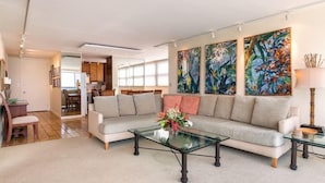 A modern living room with a sofa, coffee table, and artwork.