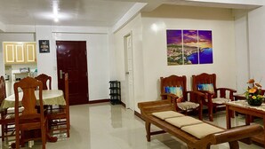 A dining area with wooden furniture, a bench, and a painting on the wall.
