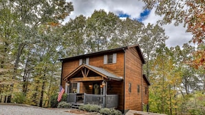 A wooden cabin with a porch, surrounded by trees. - Summers' Ridge by Mountain Oasis | Dog-Friendly Cabin in Coosawattee River Resort (Ellijay)