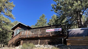A cabin with a wooden deck and a hot tub. - In the center of town with views of Longs Peak (Estes Park)