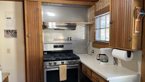 A compact kitchen with a stainless steel stove, oven, and a coffee maker on the countertop. - In the center of town with views of Longs Peak (Estes Park)