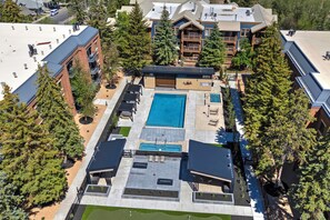 Vue aérienne d’un hôtel doté d’une piscine centrale, de nombreux balcons et entouré d’arbres.