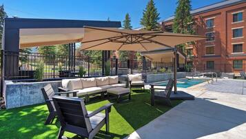 Eine Poolterrasse mit Sitzgelegenheiten und einem überdachten Bereich.
