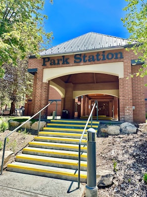 A brick building with a sign reading 'Park Station' and a set of stairs leading to the entrance.