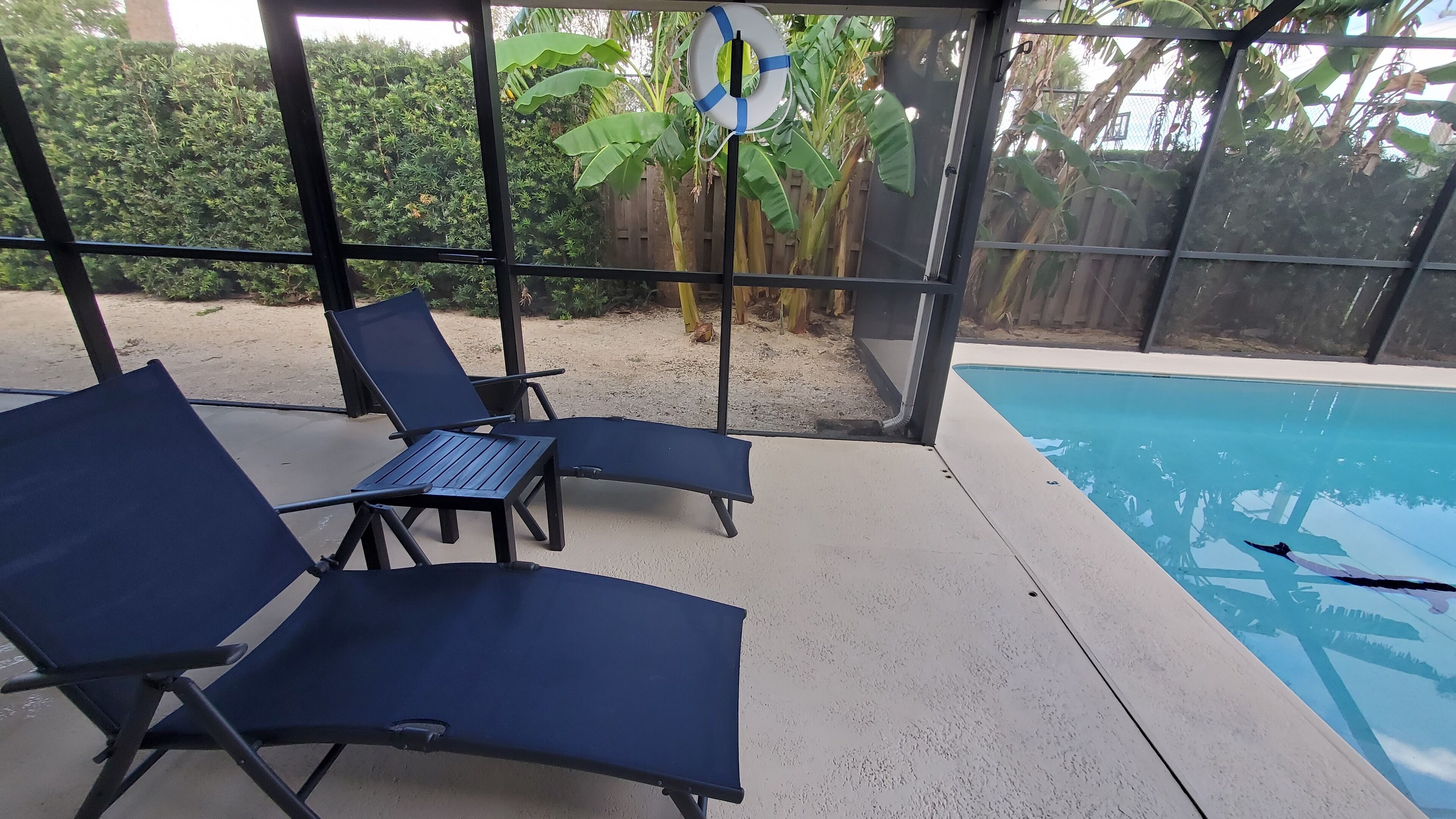 A poolside area with lounge chairs and a pool.