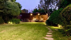 Un patio exterior bien iluminado con un sendero de piedra que conduce a una zona de estar.
