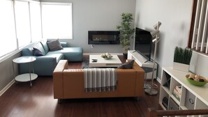 Un saló modern amb un sofà, una taula de centre i una televisió.