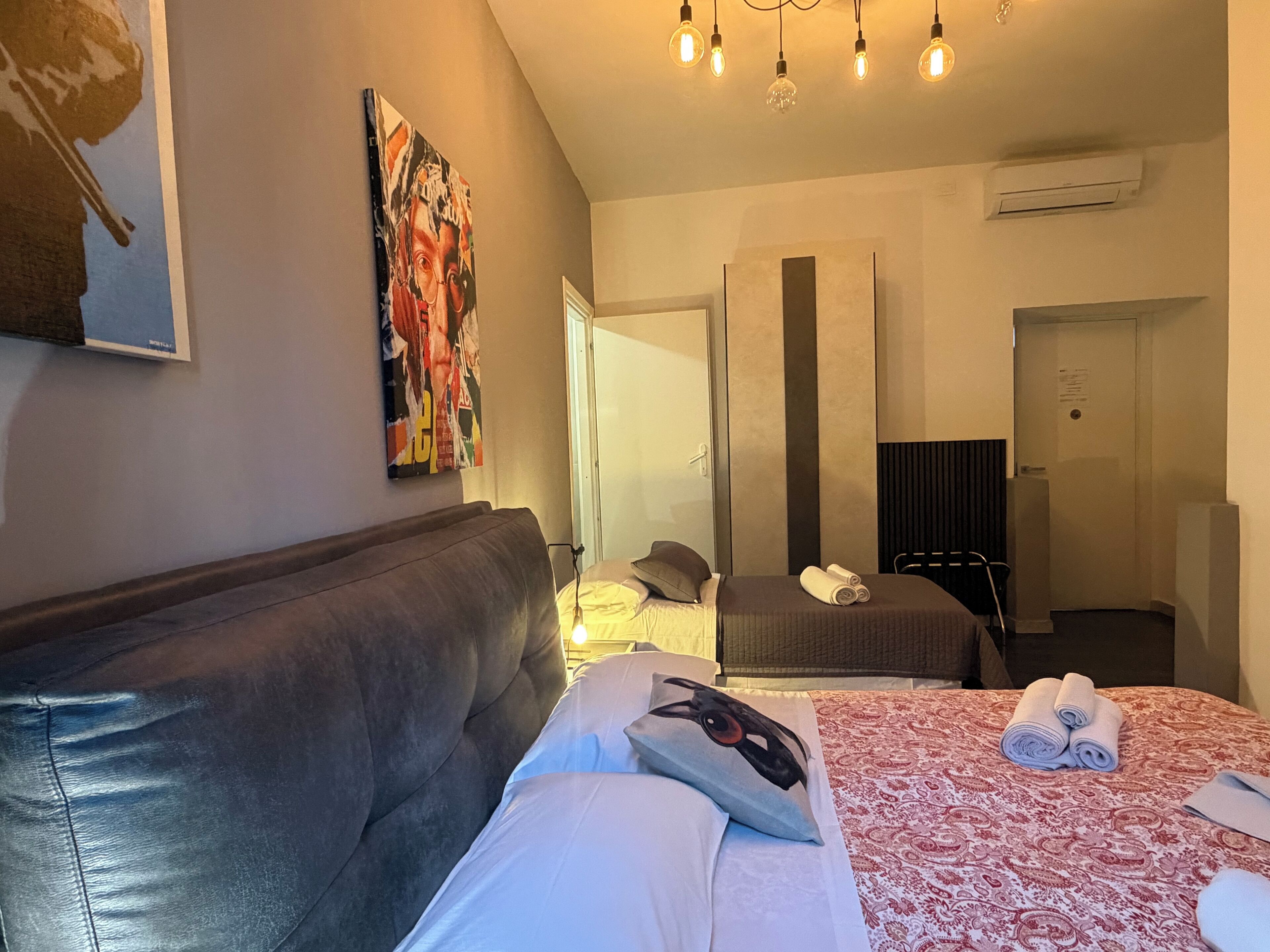 Une chambre d’hôtel avec un grand lit, un canapé, un tableau au mur et un miroir.