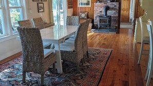 A dining area with a wooden table, wicker chairs, and a patterned rug. - Lakefront Home On Beautiful Donnells Pond,32 miles From Acadia N P and Bar Harbr (Franklin)
