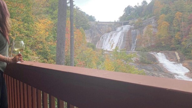 A balcony with a view of a waterfall and autumn foliage. - FALLING WATERS ~ 2b/2b SPECTACULAR VIEW HANGING OVER FALLS, UPSCALE FURNISHINGS. (Lake Toxaway)