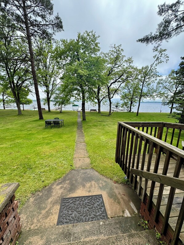 A pathway leading to a grassy area with benches and a view of the water.