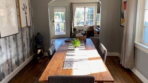 Comedor con mesa de madera, sillas y lámpara colgante.