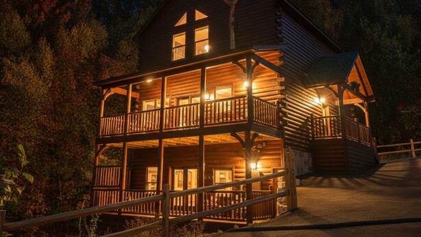 A wooden cabin with a balcony and multiple windows, surrounded by trees. - Luxury 5 King Suites, 5 Bath Log Cabin Close to Town & Trolley (Gatlinburg)