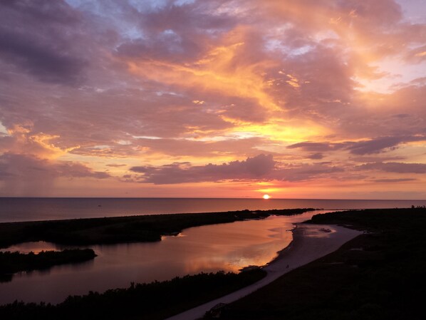 A sunset over a calm body of water with a path leading to a distant shoreline. - Beautiful, Oceanfront South Seas NW Condo with Stunning Views (Marco Island)