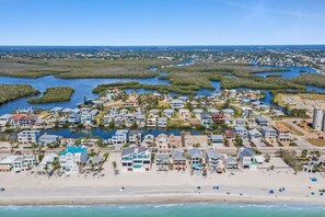 A coastal residential area with beachfront properties, a marina, and a dense cluster of houses.