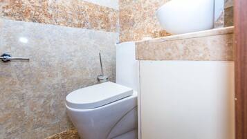 Un baño con inodoro, bidé y lavabo.