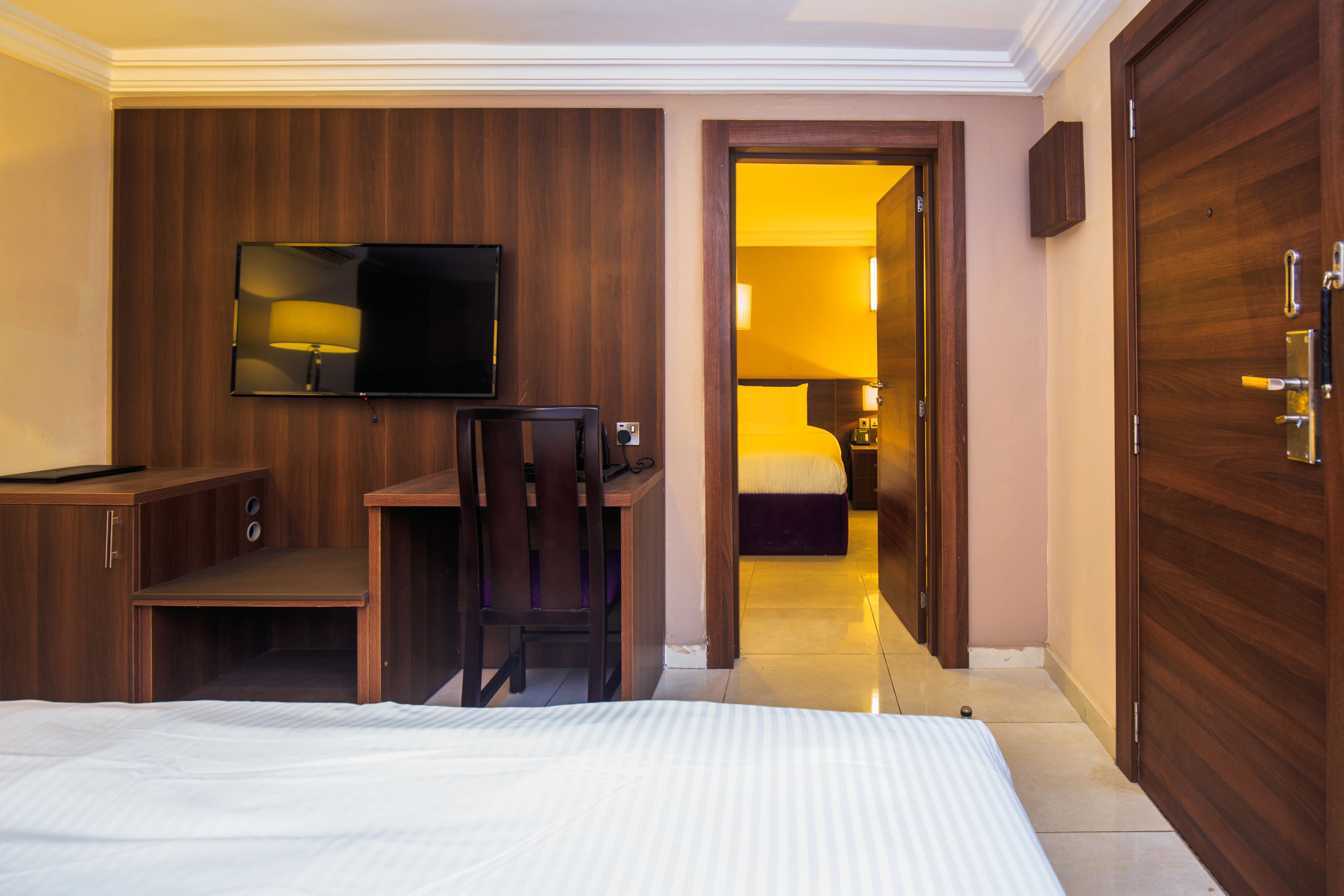 Une chambre d’hôtel équipée d’un lit, d’un bureau, d’une chaise, d’une télévision et d’une armoire.