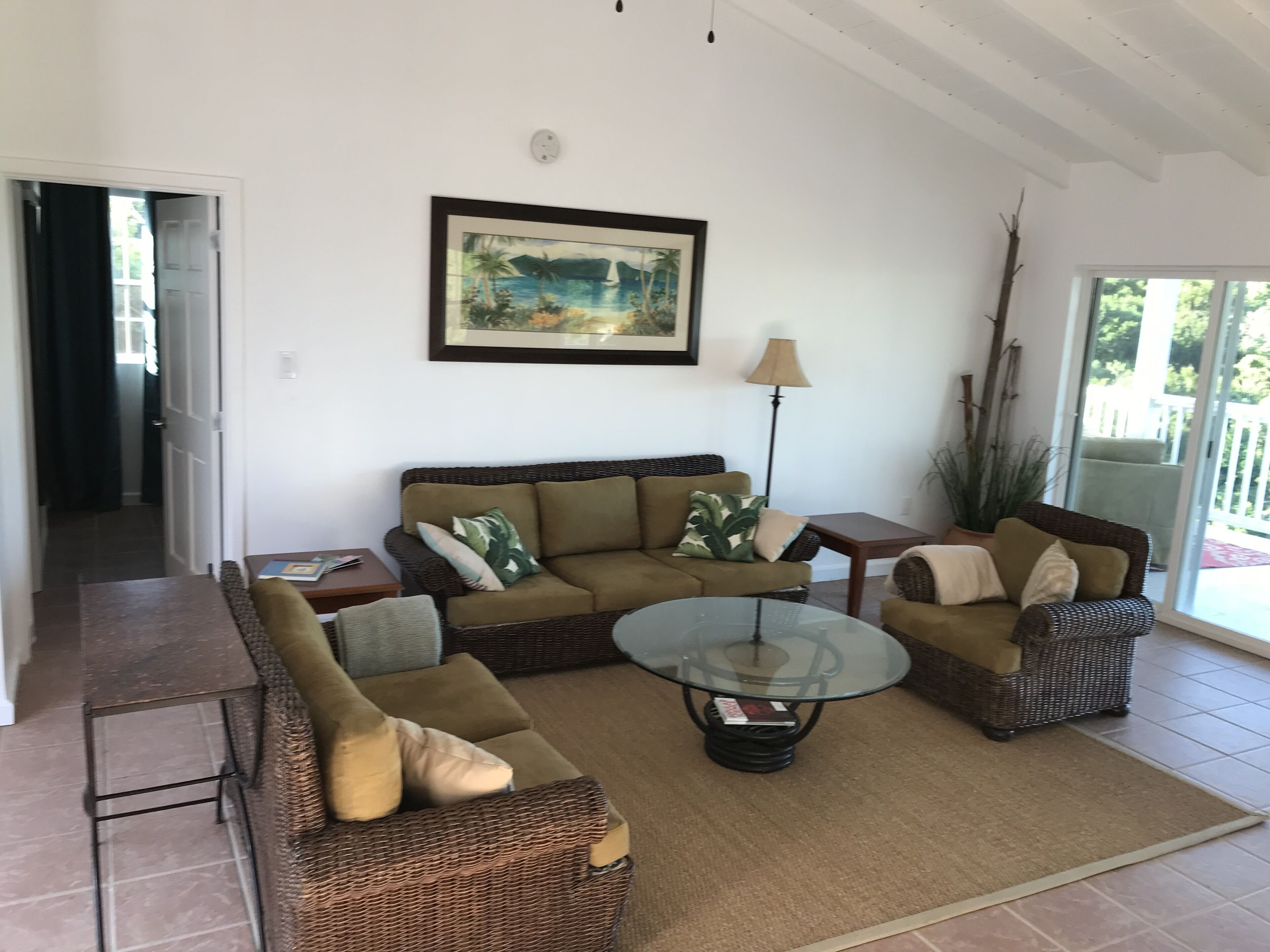 A living room with a sofa set, a coffee table, and a painting on the wall.