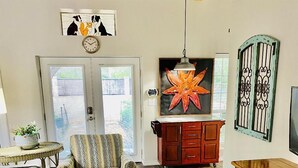 Een woonkamer met een bank, gestreept fauteuil, salontafel, houten kast en een televisie.