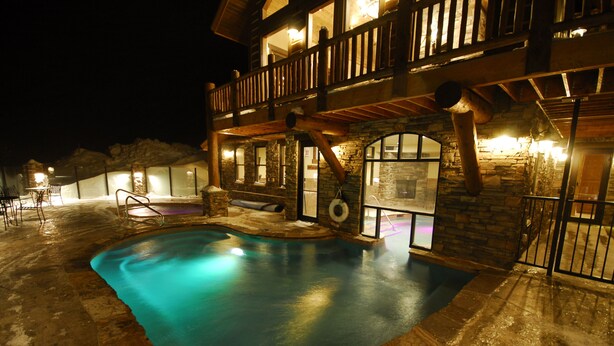 A multi-level stone building with a swimming pool. - Luxury Big Sky Mountain Home With Private Lodge, Pool & Ski in/out access (Big Sky)