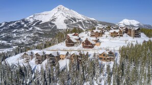 A snow-covered lodge with multiple buildings, surrounded by trees and mountains. - Luxury Big Sky Mountain Home With Private Lodge, Pool & Ski in/out access (Big Sky)