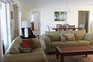 A living room with two sofas, a coffee table, and a dining table with chairs.