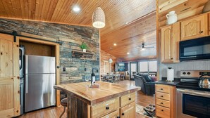 Una cocina moderna con armarios de madera, un refrigerador de acero inoxidable y una isla central con cajones.