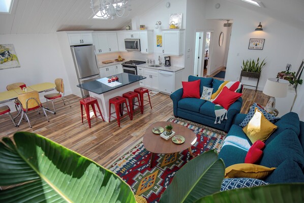 A compact living space with a kitchenette, a dining area, and a seating area with a sofa and chairs. - Runaway Rooster B&B -- Guest Cottage
 (Prince Edward)