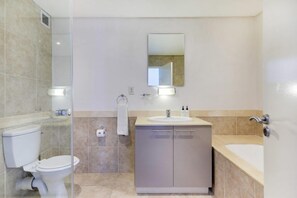 Uma casa de banho moderna com sanita, lavatório e banheira.