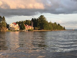 A waterfront property with a house and a lighthouse in the background.