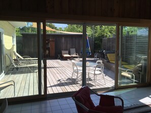 Relax in a comfortable outdoor space with lounge chairs and a dining table, surrounded by a clear view of the backyard.