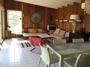 Relax in this inviting living area with a sofa, flat-screen TV, and dining table.