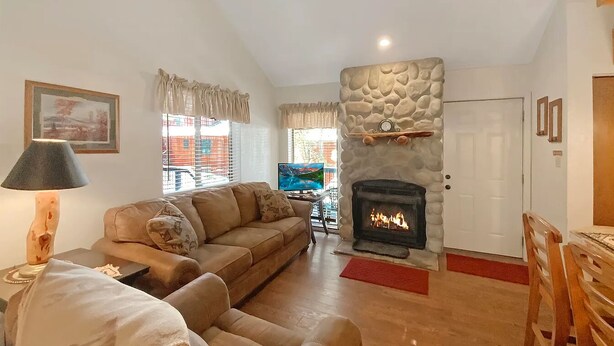 A living room with a sofa, armchair, and a fireplace. - Angel Fire Chalet park and walk (Angel Fire)