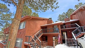 A two-story wooden building with a staircase leading to the upper floor. - Angel Fire Chalet park and walk (Angel Fire)