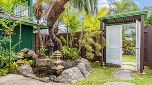 A garden with a pond, rocks, and a pagoda.