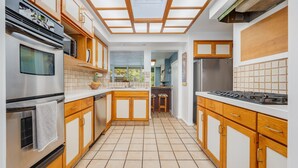 A modern kitchen with wooden cabinets, a stainless steel stove, and a tiled backsplash.