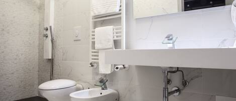 A modern bathroom with a toilet, bidet, and shower.